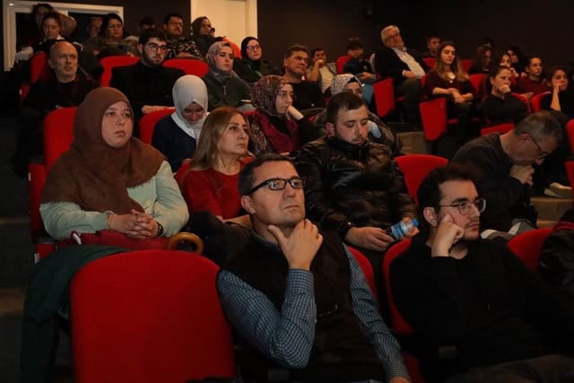 Düşünceli katılımcılar konferansı dinlerken canlı ve dikkatli.